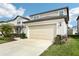 Exterior view of a charming two-story home featuring a two car garage and landscaped front yard at 29985 Marquette Ave, Wesley Chapel, FL 33545