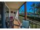 Covered balcony with brick floors and views of the tennis court and palm trees at 3021 Countryside Blvd # 24A, Clearwater, FL 33761