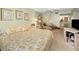 Comfortable bedroom features a floral bedspread, seating area, and a view to the ensuite bathroom at 3021 Countryside Blvd # 24A, Clearwater, FL 33761
