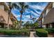 Attractive condo buildings with palm trees, manicured hedges and the American flag flying on a sunny day at 3021 Countryside Blvd # 24A, Clearwater, FL 33761