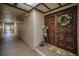 Condo entrance featuring an ornate wooden door, white wreath, and textured walls at 3021 Countryside Blvd # 24A, Clearwater, FL 33761