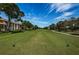 Beautiful view of the golf course with green grass, blue sky, and trees in the background at 3021 Countryside Blvd # 24A, Clearwater, FL 33761