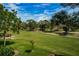 Scenic golf course view features mature trees, manicured greens, and a meandering path under a bright sky at 3021 Countryside Blvd # 24A, Clearwater, FL 33761