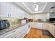 Bright kitchen featuring white appliances, stylish countertops, ample cabinetry, and a modern ceiling fan at 3021 Countryside Blvd # 24A, Clearwater, FL 33761