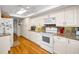 Updated kitchen with white cabinets, granite countertops, hardwood floors and stainless steel appliances at 3021 Countryside Blvd # 24A, Clearwater, FL 33761