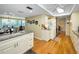 Open-concept kitchen with a breakfast bar, granite countertops, white cabinetry, and hardwood floors at 3021 Countryside Blvd # 24A, Clearwater, FL 33761