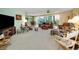 Spacious living room featuring carpet floors, sliding glass doors, and a ceiling fan at 3021 Countryside Blvd # 24A, Clearwater, FL 33761