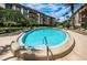 Community pool with blue water and building backdrop, surrounded by mature trees and blue sky with cloud cover at 3021 Countryside Blvd # 24A, Clearwater, FL 33761