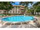 Community pool with sunny skies and plenty of lounge chairs for residents to enjoy the outdoors at 3021 Countryside Blvd # 24A, Clearwater, FL 33761