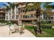 Inviting patio with table, chairs, and beautiful in-ground community pool amidst lush landscaping and well-maintained buildings at 3021 Countryside Blvd # 24A, Clearwater, FL 33761
