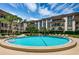 Community in-ground pool with clear blue water, surrounded by well-maintained landscaping and multi-story buildings under a bright, sunny sky at 3021 Countryside Blvd # 24A, Clearwater, FL 33761