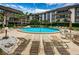 Inviting community pool featuring surrounding lounge chairs and tables under a partly cloudy sky at 3021 Countryside Blvd # 24A, Clearwater, FL 33761