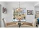 Bright dining area features a glass table, modern chandelier, and lovely views of the landscaped backyard at 3323 Ringwood Mdw, Sarasota, FL 34235
