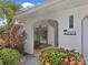 Covered front entryway with tropical landscaping, stone tile and decorative house number at 3323 Ringwood Mdw, Sarasota, FL 34235