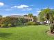 Spacious front yard with verdant lawn, mature palms, and colorful landscaping offering great curb appeal at 3323 Ringwood Mdw, Sarasota, FL 34235