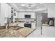 Modern kitchen features granite countertops, stainless steel appliances, white cabinets, and ample counter space at 3323 Ringwood Mdw, Sarasota, FL 34235