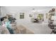 Bright living room with white tile floors, piano, and elegant dining area at 3323 Ringwood Mdw, Sarasota, FL 34235