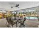 Relaxing screened-in patio with outdoor dining area, ceiling fan, and view of the pool at 3323 Ringwood Mdw, Sarasota, FL 34235