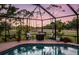 Relax in this screened-in pool area, surrounded by lush landscaping and open views at 3323 Ringwood Mdw, Sarasota, FL 34235