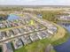 An aerial view of a neighborhood showcasing well-maintained homes nestled by a tranquil lake at 33886 Landsman Loop, Wesley Chapel, FL 33543