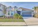 Beautifully landscaped home with a two-car garage, lush greenery, and a well-kept lawn at 33886 Landsman Loop, Wesley Chapel, FL 33543