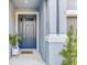 Stylish entryway featuring a blue front door, decorative columns, and a welcoming 