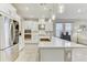 Modern kitchen with stainless steel appliances, a large island, pendant lights, and white cabinets at 33886 Landsman Loop, Wesley Chapel, FL 33543