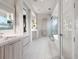 Spacious bathroom showcasing double vanities, soaking tub, walk-in shower, and tile flooring at 5131 W Neptune Way, Tampa, FL 33609