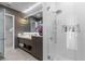 Modern bathroom showcasing textured walls, stylish lighting, and a spacious glass enclosed shower at 5131 W Neptune Way, Tampa, FL 33609