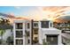 Striking modern home with sleek lines, balconies, and a beautiful sunset, blending architectural design with natural beauty at 5131 W Neptune Way, Tampa, FL 33609