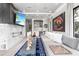 Living room featuring a modern fireplace, gray sofa, and a bar area in the background at 5131 W Neptune Way, Tampa, FL 33609