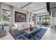 Living room showcasing a gray sofa, modern art, and sliding glass doors leading to the outdoors at 5131 W Neptune Way, Tampa, FL 33609
