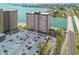 This aerial view showcases the waterfront condo buildings, swimming pool, parking lot, and a scenic bridge nearby at 5220 Brittany S Dr # 210, St Petersburg, FL 33715
