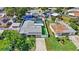 A birds eye view of a home with an enclosed screened pool, gray roof, and green turf at 5248 Coral N Way, St Petersburg, FL 33714
