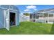 Large green backyard featuring a shed and a screened-in pool area, perfect for outdoor activities at 5248 Coral N Way, St Petersburg, FL 33714