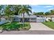 Charming home with a lush front yard, a palm tree, updated stone exterior and a well-maintained lawn at 5248 Coral N Way, St Petersburg, FL 33714
