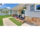 Inviting front porch featuring stone accents, seating area, and beautiful landscaping at 5248 Coral N Way, St Petersburg, FL 33714