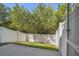 Fenced backyard with green grass area, gray wood deck, and mature trees for privacy and outdoor enjoyment at 542 Black Lion Ne Dr, St Petersburg, FL 33716