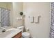 This bathroom features a white sink, toilet, and a shower-tub with floral curtains at 542 Black Lion Ne Dr, St Petersburg, FL 33716