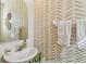 Stylish half bathroom featuring modern sink, patterned wallpaper, and a bright mirror at 542 Black Lion Ne Dr, St Petersburg, FL 33716