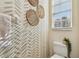 Charming half bathroom featuring patterned wallpaper, a toilet and bright window at 542 Black Lion Ne Dr, St Petersburg, FL 33716