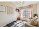 Charming bedroom boasts a cozy sofa, decorative macrame, soft pink curtains, and natural light for a serene retreat at 542 Black Lion Ne Dr, St Petersburg, FL 33716