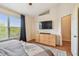 This bedroom features a large window, wood floors, and a flat screen TV mounted above a dresser at 542 Black Lion Ne Dr, St Petersburg, FL 33716