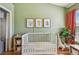 Bright Bedroom features green walls, a white crib, animal artwork, and playful decor for a cozy, inviting space at 542 Black Lion Ne Dr, St Petersburg, FL 33716