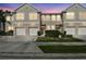 Townhome exterior with white garage doors, neutral paint, and manicured landscaping at 542 Black Lion Ne Dr, St Petersburg, FL 33716
