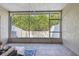 Private screened patio featuring a cozy seating area and a serene view of the lush, fenced backyard at 542 Black Lion Ne Dr, St Petersburg, FL 33716