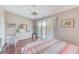 Inviting bedroom with wood floors, a ceiling fan, and sliding glass doors leading to a charming balcony at 615 Garland Cir, Indian Rocks Beach, FL 33785