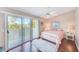 Comfortable bedroom features a ceiling fan, wood floors, and sliding glass doors leading to a private balcony at 615 Garland Cir, Indian Rocks Beach, FL 33785