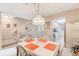 Bright dining area with seating for four, and a view of the open kitchen and carpeted staircase at 615 Garland Cir, Indian Rocks Beach, FL 33785