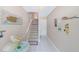 Neutral foyer featuring tiled floors, stairway, interior door, and coastal-themed decorations at 615 Garland Cir, Indian Rocks Beach, FL 33785